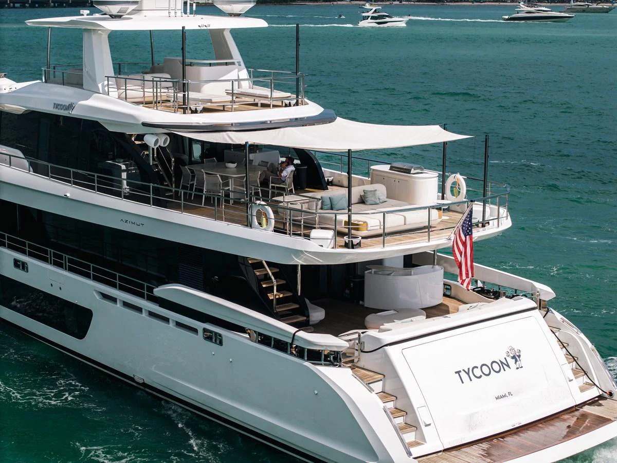 The yacht features a spacious aft deck with elegant seating and a shaded area for relaxation. aboard TYCOON Yacht for Sale