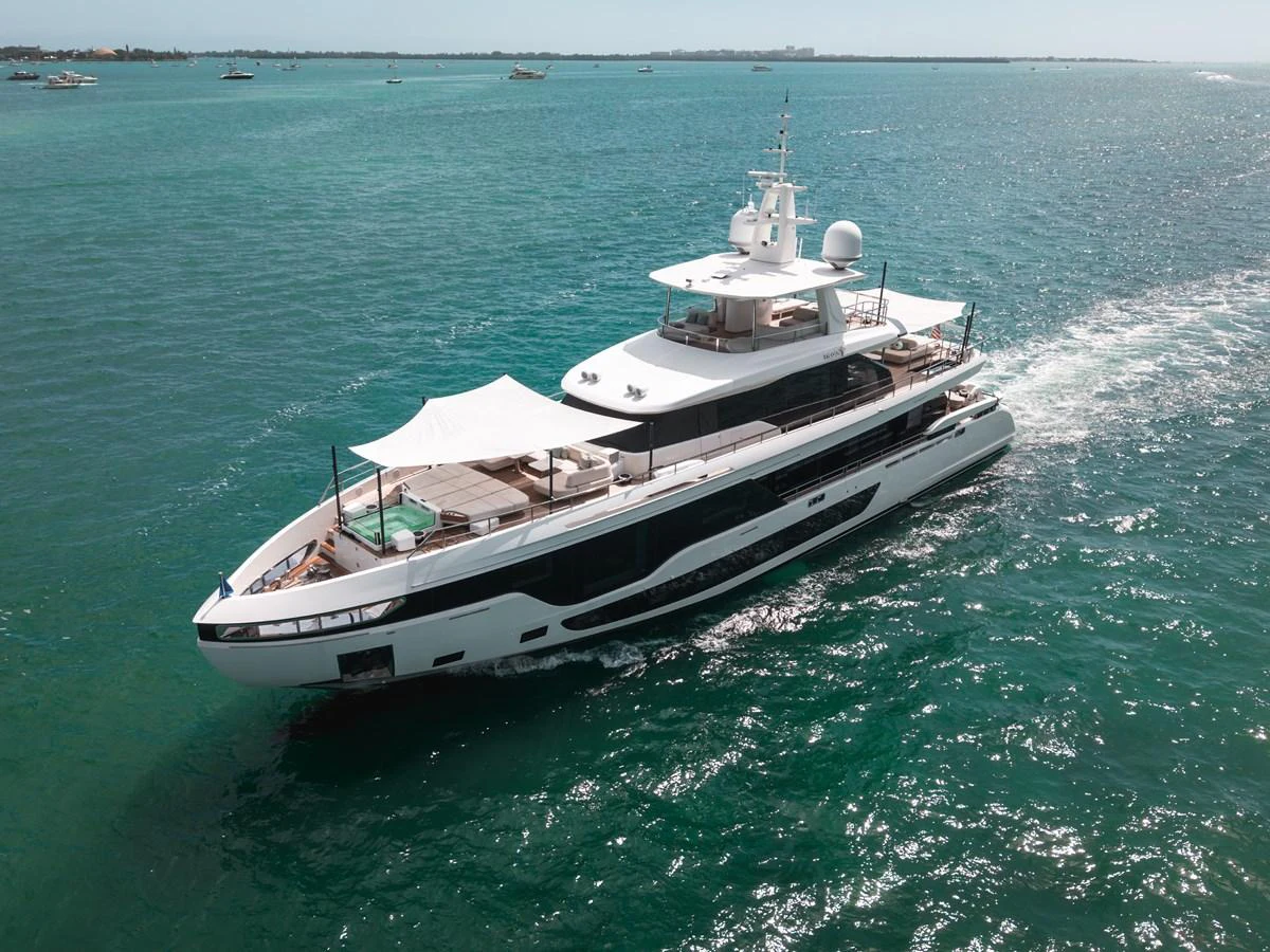 A luxurious yacht cruises through clear blue waters, showcasing its sleek design and spacious decks. aboard TYCOON Yacht for Sale