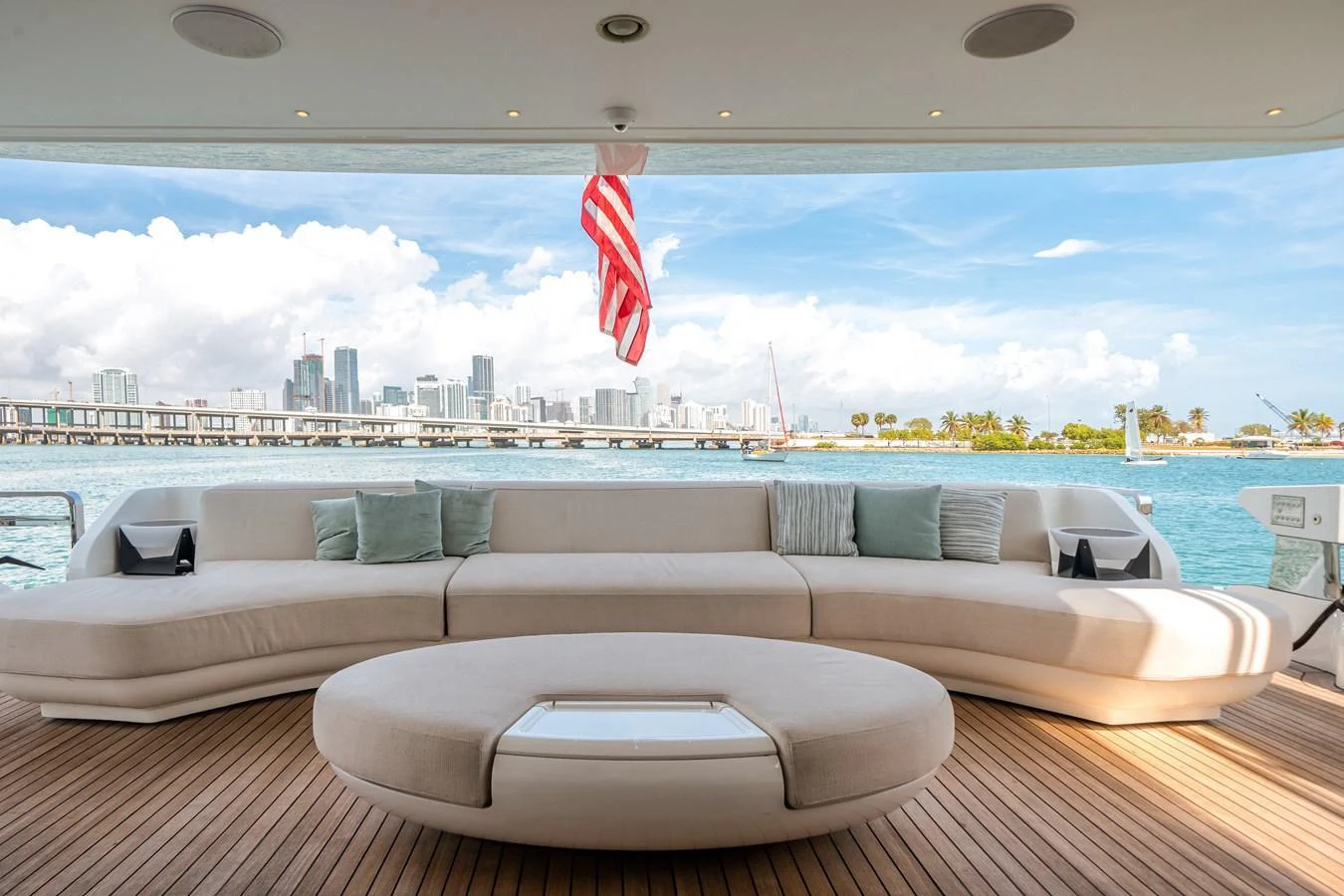 The aft deck features a spacious seating area with a stunning view of the city skyline. aboard TYCOON Yacht for Sale