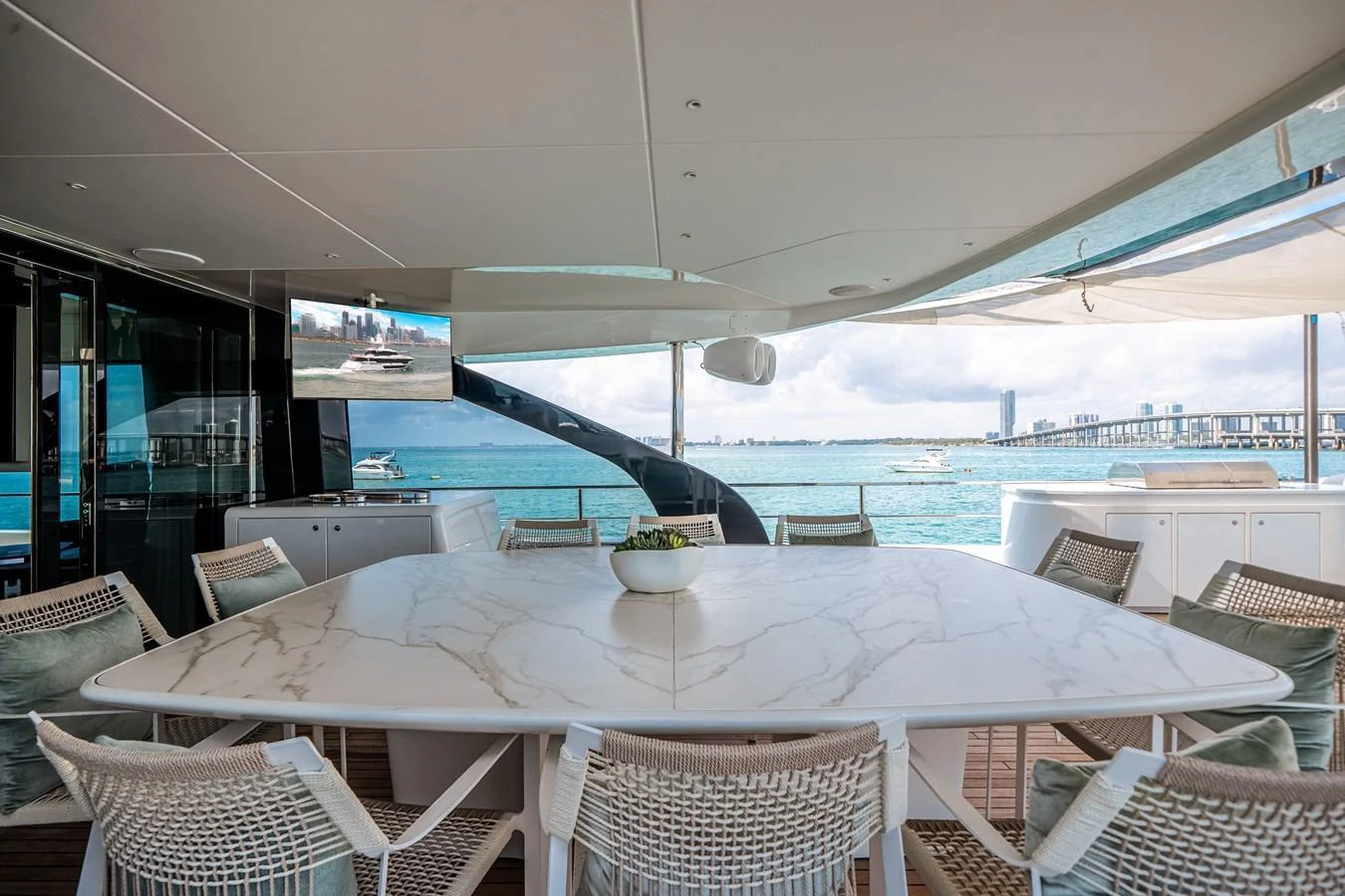 The aft deck features a spacious dining area with a large marble table and comfortable seating, perfect for enjoying meals with a view of the sea. aboard TYCOON Yacht for Sale