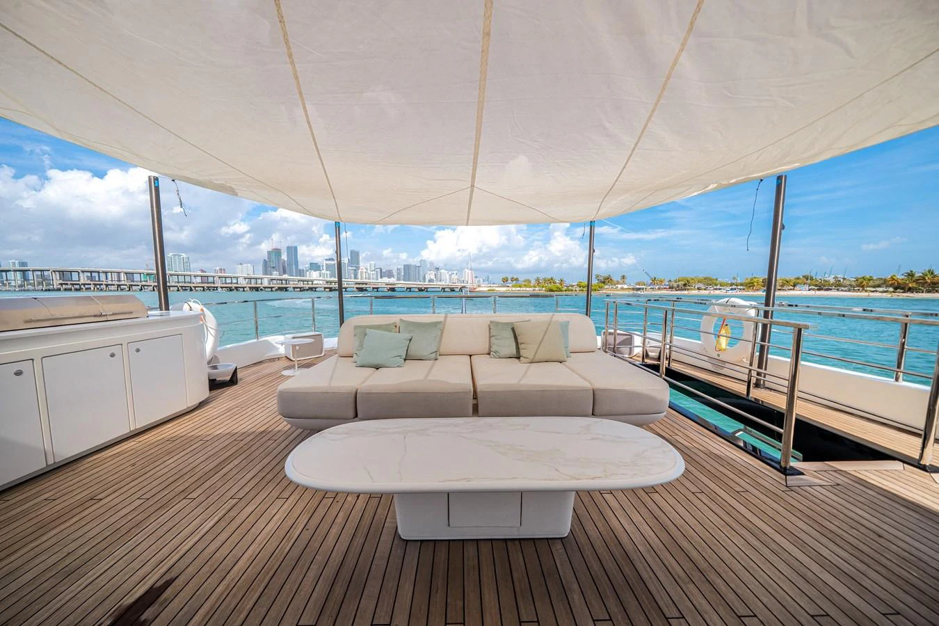 The aft deck features a spacious seating area with a modern table, shaded by a large canopy, perfect for relaxing and enjoying the view. aboard TYCOON Yacht for Sale