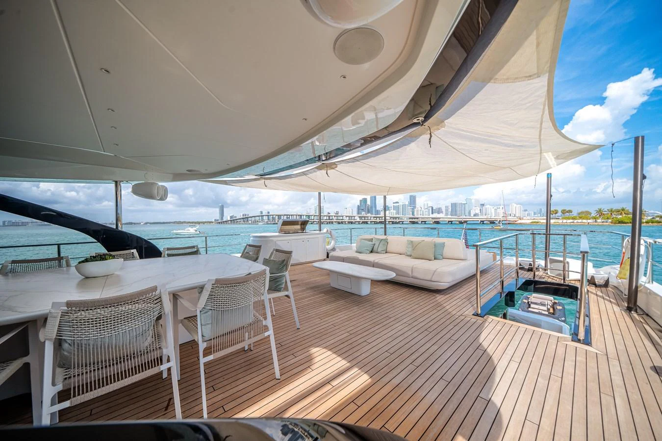 The aft deck offers a spacious and luxurious outdoor living area with stunning views of the city skyline. aboard TYCOON Yacht for Sale