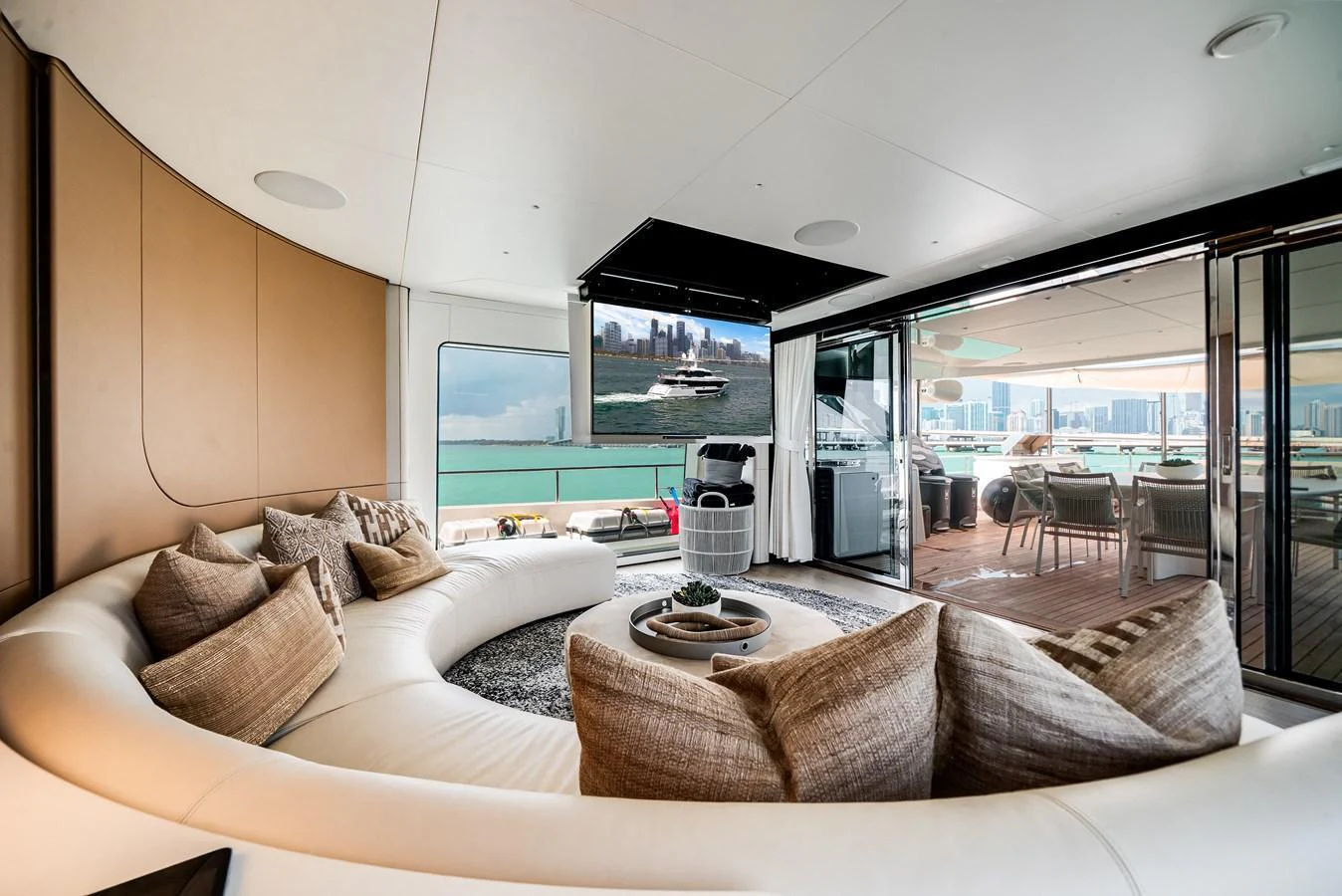 The spacious salon features a large curved sofa with plush cushions, offering a luxurious and comfortable setting with a view of the sea. aboard TYCOON Yacht for Sale