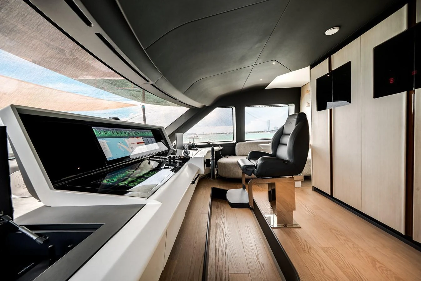The helm station features advanced navigation equipment and a comfortable captain's chair, set in a sleek, modern interior. aboard TYCOON Yacht for Sale