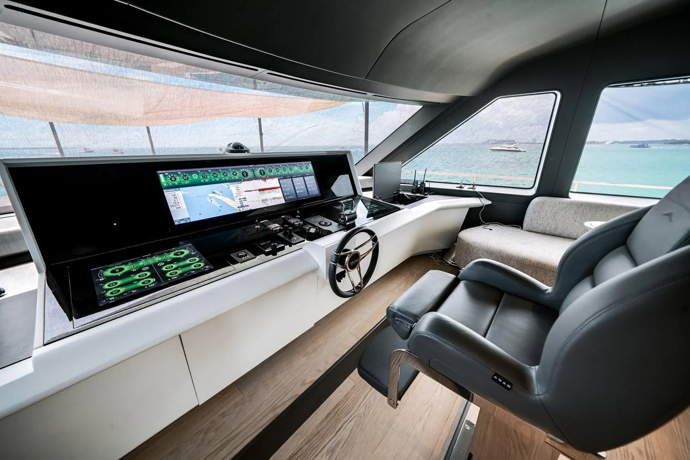 The helm station offers a sleek and modern design with advanced navigation equipment and a comfortable captain's chair. aboard TYCOON Yacht for Sale