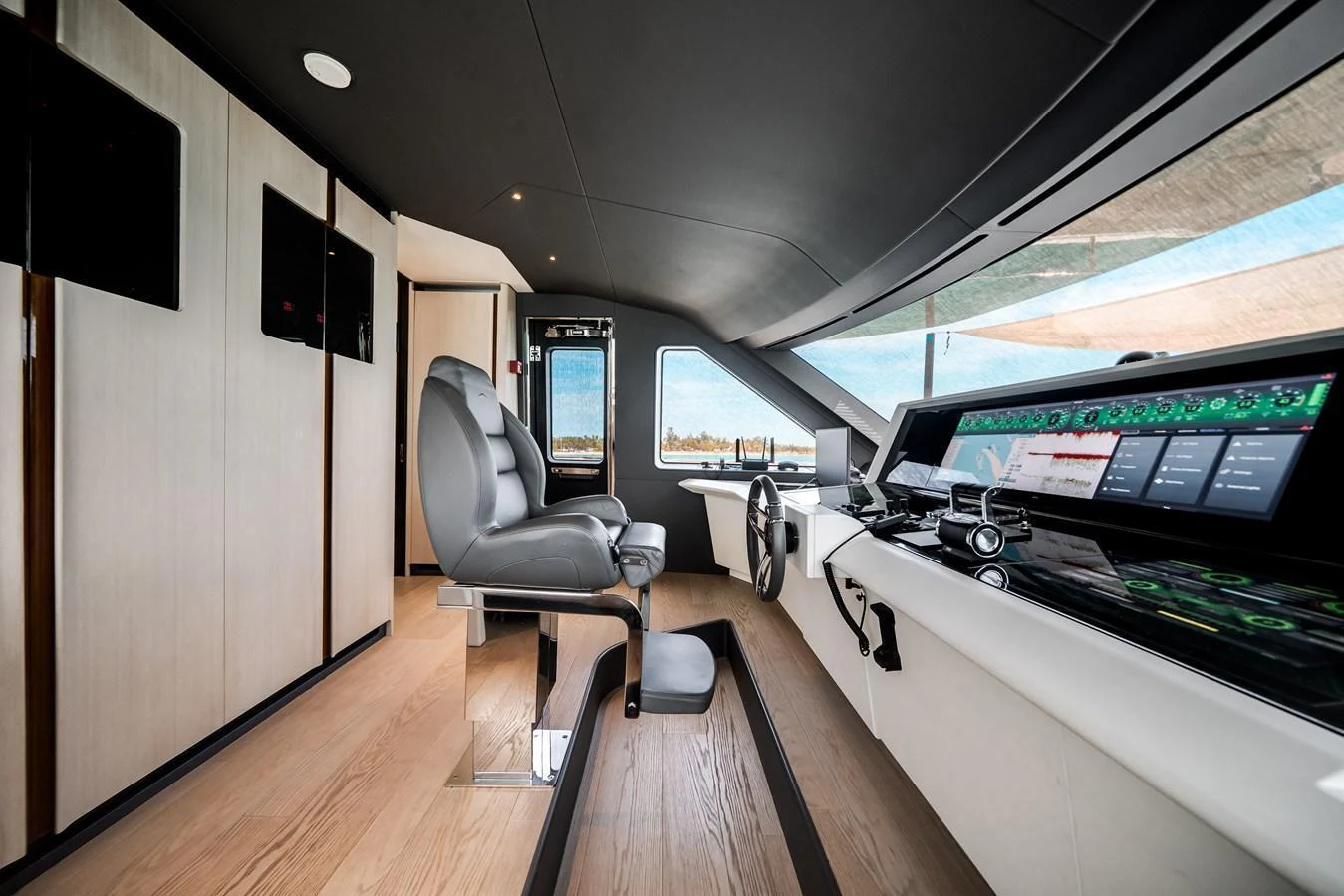 The helm station features modern navigation equipment and a comfortable captain's chair with a panoramic view. aboard TYCOON Yacht for Sale