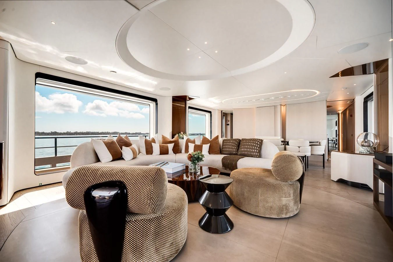 The salon features plush seating with panoramic views through large windows, creating a luxurious and inviting atmosphere. aboard TYCOON Yacht for Sale