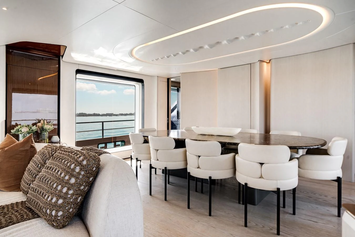 The yacht's dining area features a large table surrounded by plush chairs, offering a luxurious setting with a view of the sea. aboard TYCOON Yacht for Sale