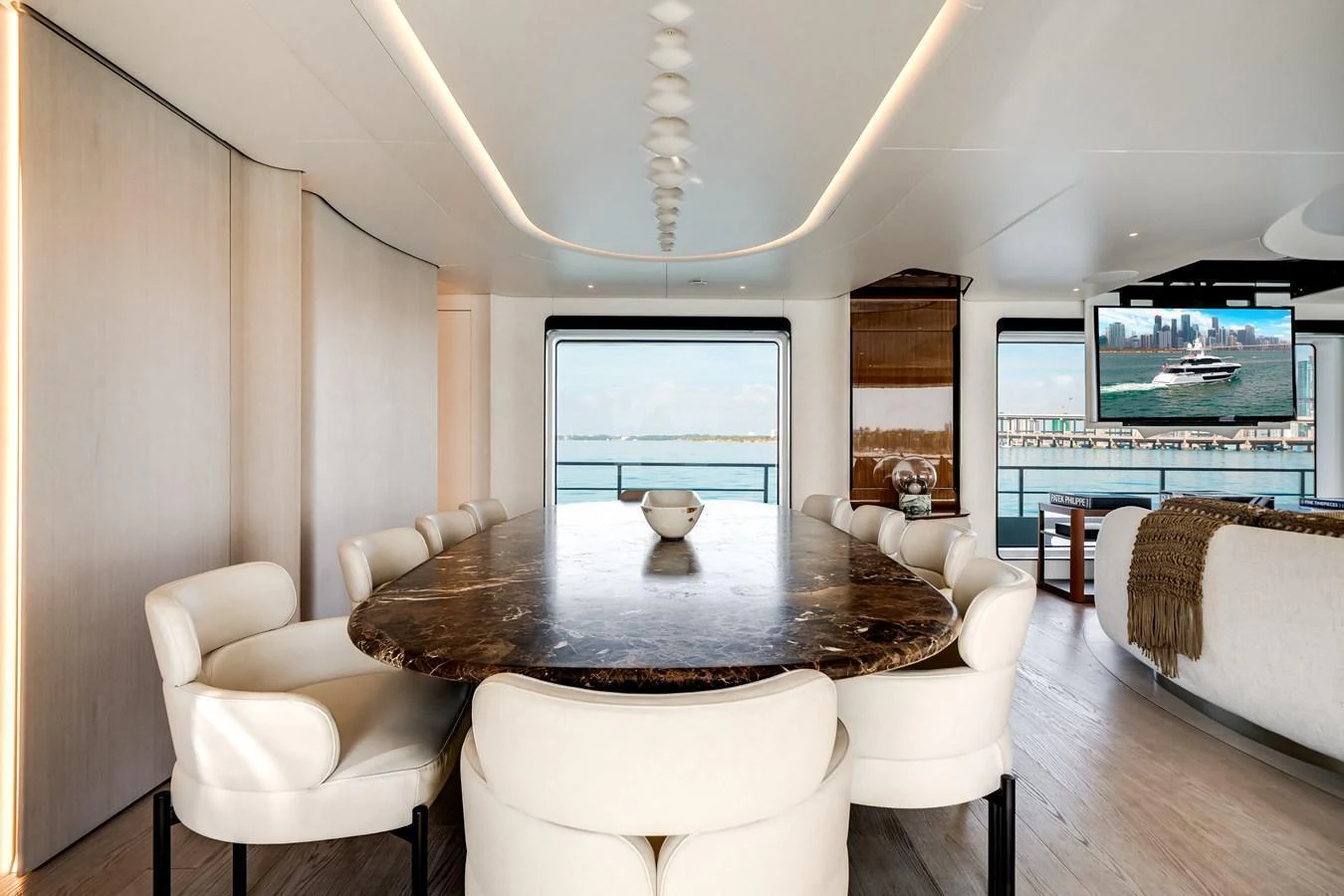 The yacht's dining area features a luxurious table with plush seating and panoramic views. aboard TYCOON Yacht for Sale