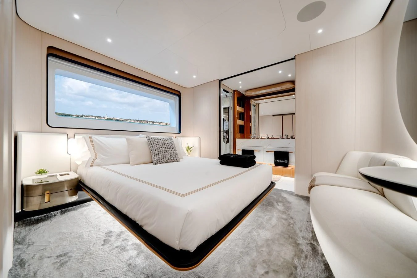 A luxurious stateroom featuring a large bed, modern furnishings, and a scenic window view. aboard TYCOON Yacht for Sale