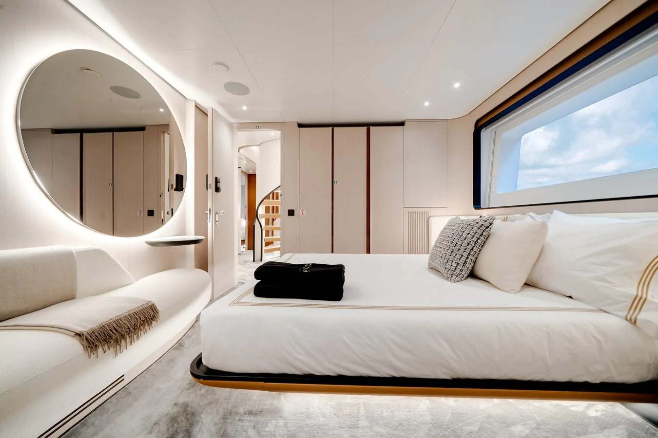 The stateroom features a luxurious bed, modern decor, and ample natural light from the large window. aboard TYCOON Yacht for Sale