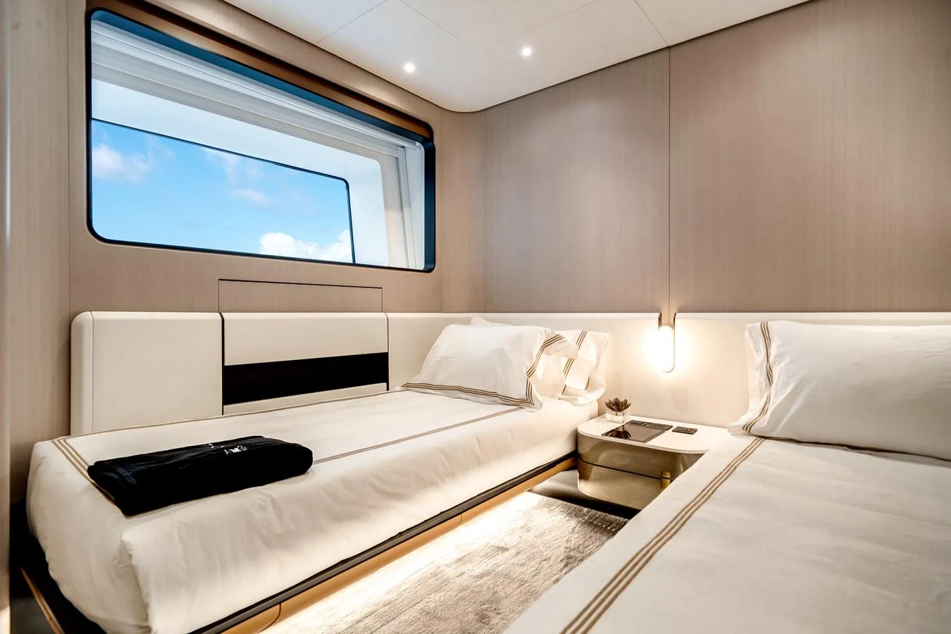 The guest stateroom features twin beds with a large window offering a view of the sea. aboard TYCOON Yacht for Sale