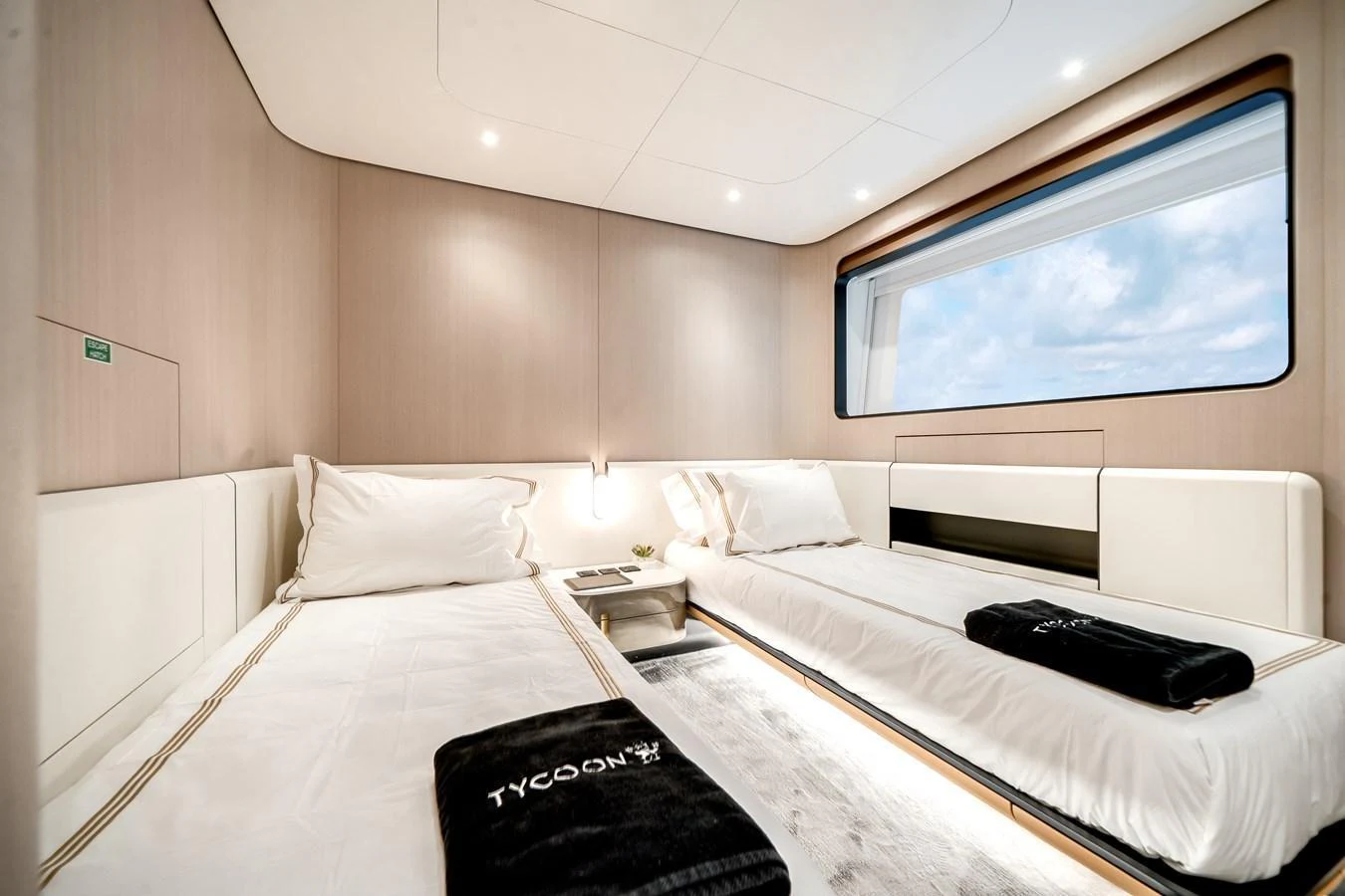 The guest stateroom features twin beds with a large window offering a view of the sea. aboard TYCOON Yacht for Sale