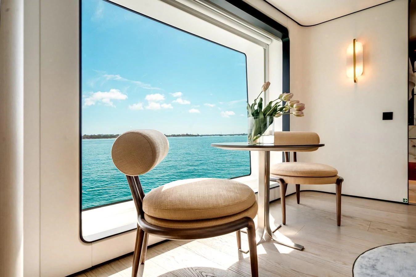 A serene dining area with a large window offering a stunning view of the sea. aboard TYCOON Yacht for Sale