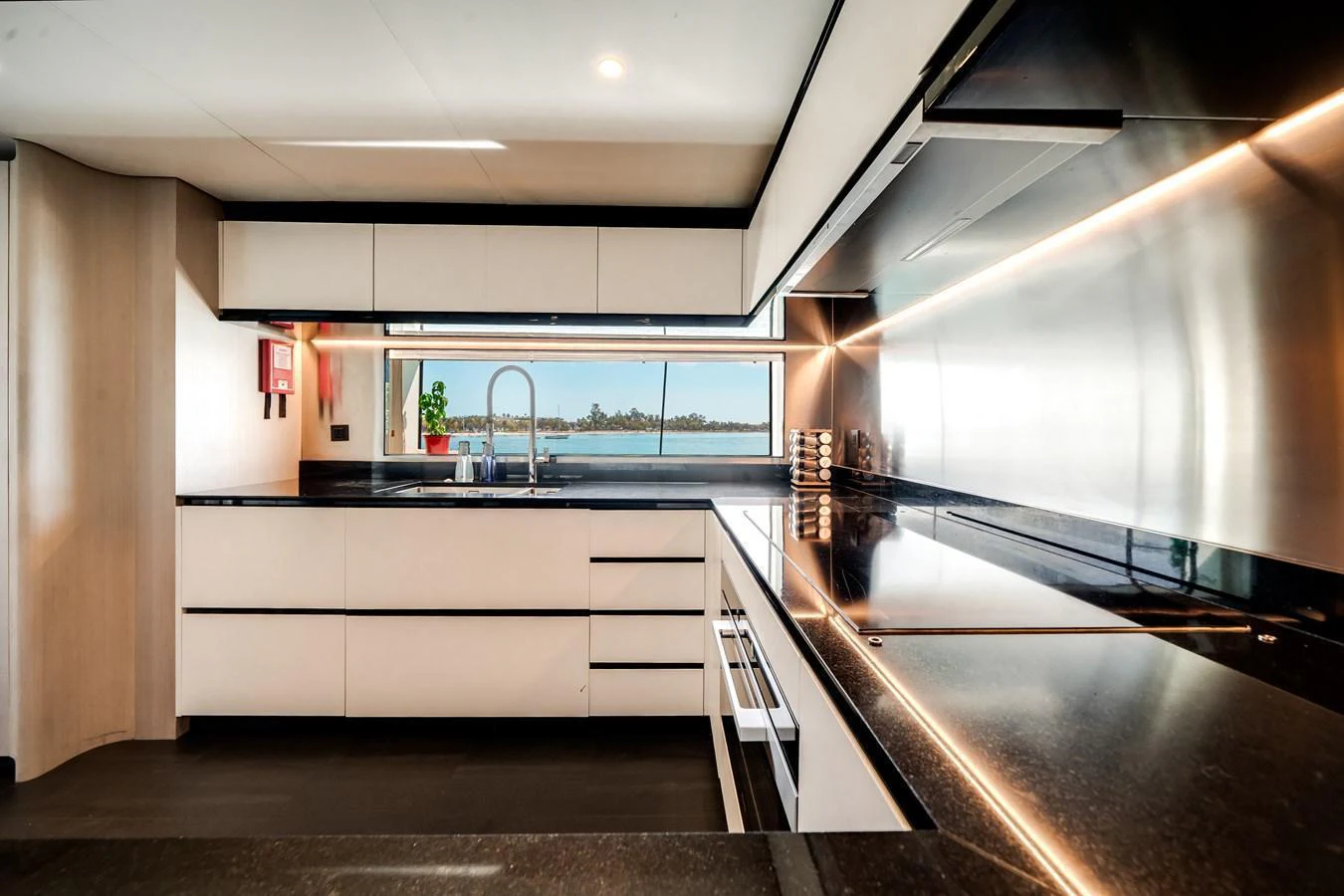 The sleek and modern galley offers a stunning view through large windows, combining functionality with elegance. aboard TYCOON Yacht for Sale