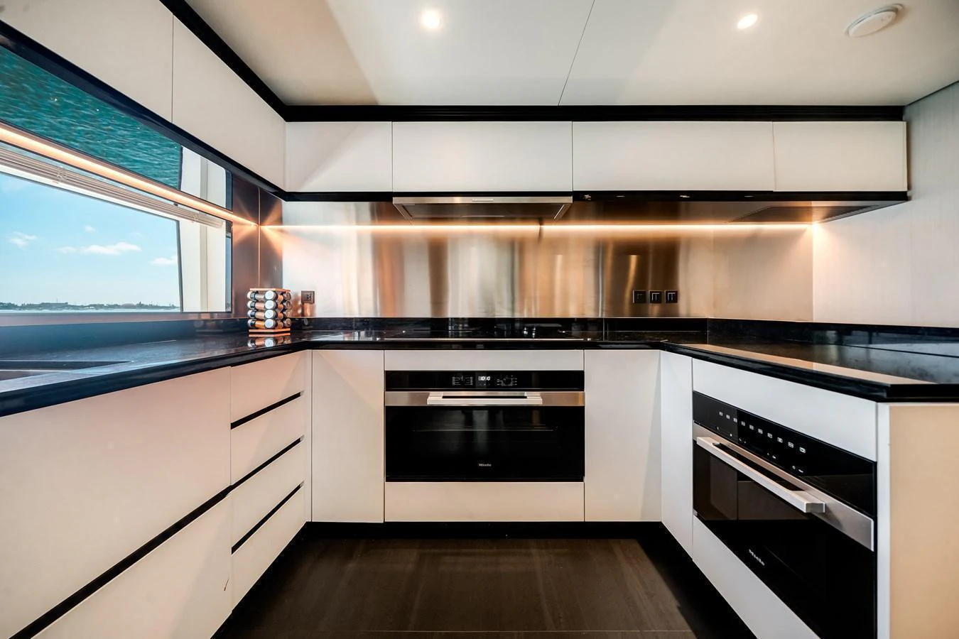 The yacht's galley features sleek, modern appliances and ample counter space with a view of the sea. aboard TYCOON Yacht for Sale