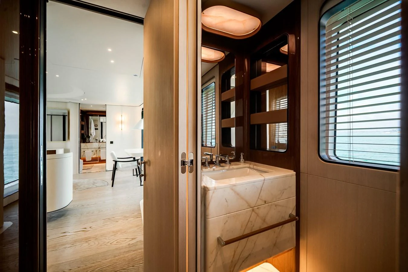 A luxurious yacht interior featuring a modern bathroom and a glimpse into a stylish living area. aboard TYCOON Yacht for Sale