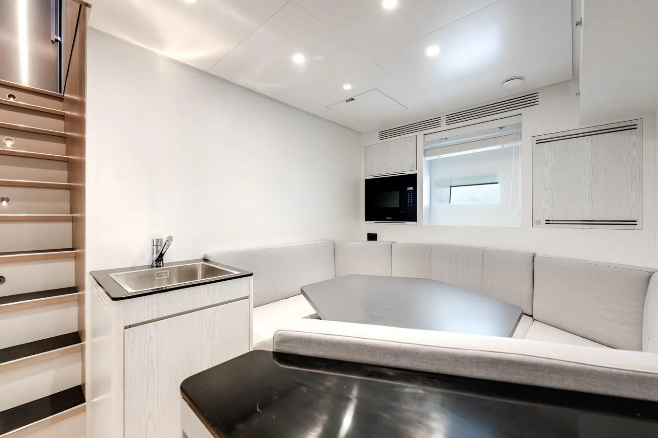The yacht's saloon features a cozy seating area with a modern, minimalist design. aboard TYCOON Yacht for Sale