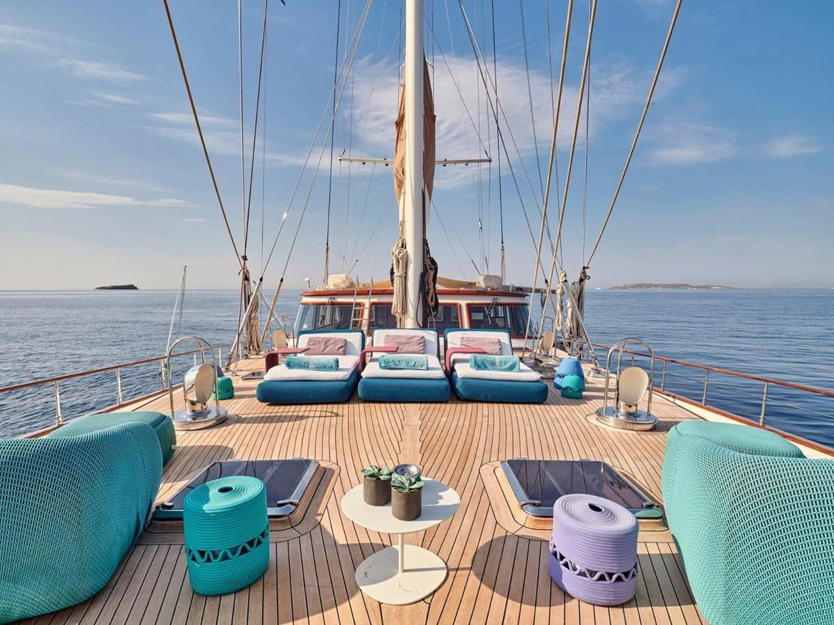 a deck with a table and chairs on it aboard PASA Yacht for Sale