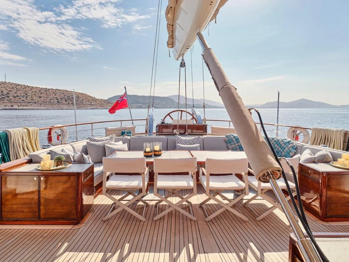 a deck with a table and chairs on it aboard PASA Yacht for Sale