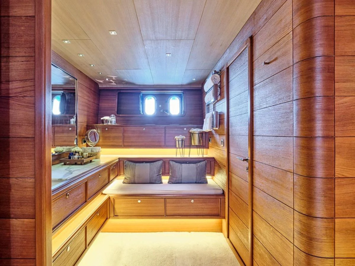 a room with a wood wall and a bed aboard PASA Yacht for Sale