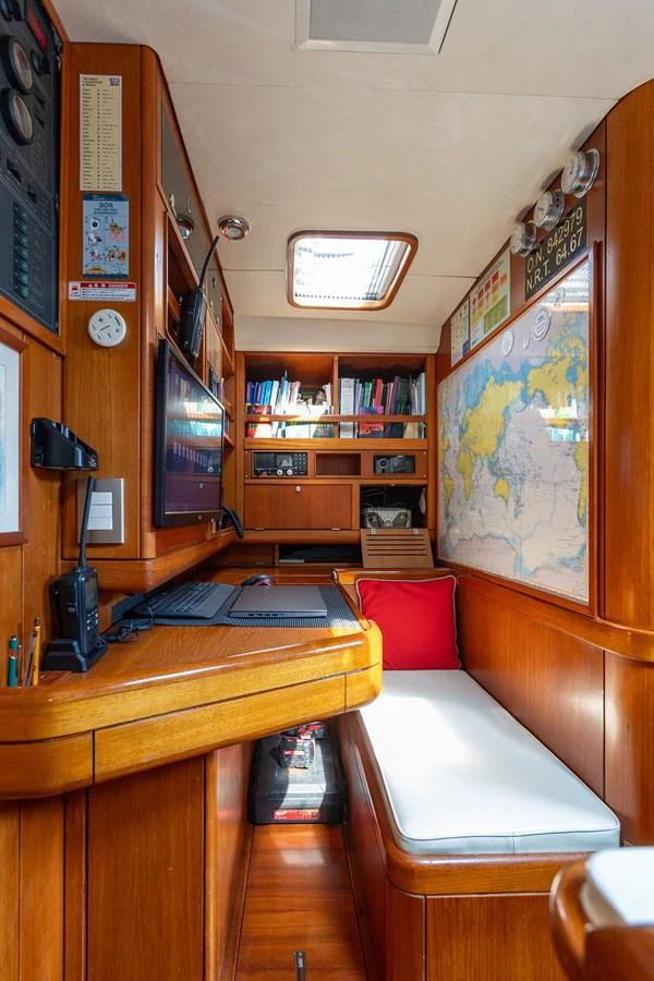 a living room with a book shelf and a couch aboard SKIP'N BOU Yacht for Sale