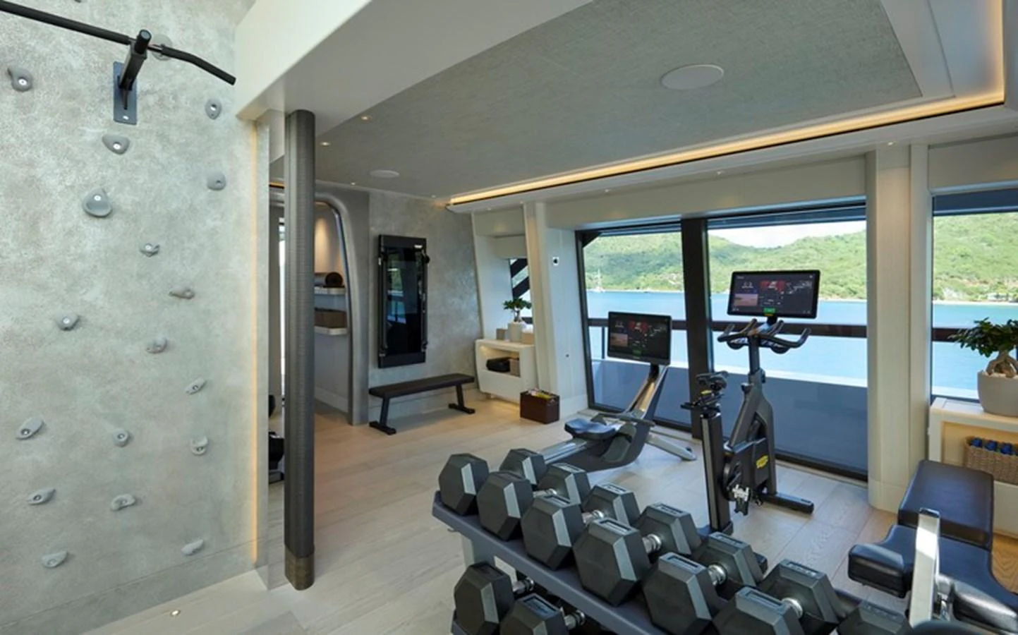 a room with a treadmill and a large window aboard VANISH Yacht for Sale