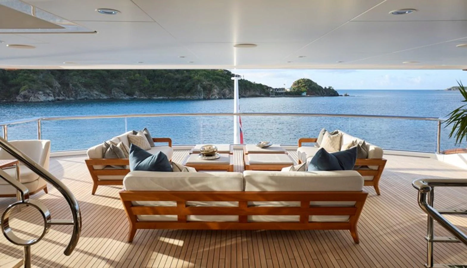 a lounge area with chairs and a body of water in the background aboard VANISH Yacht for Sale