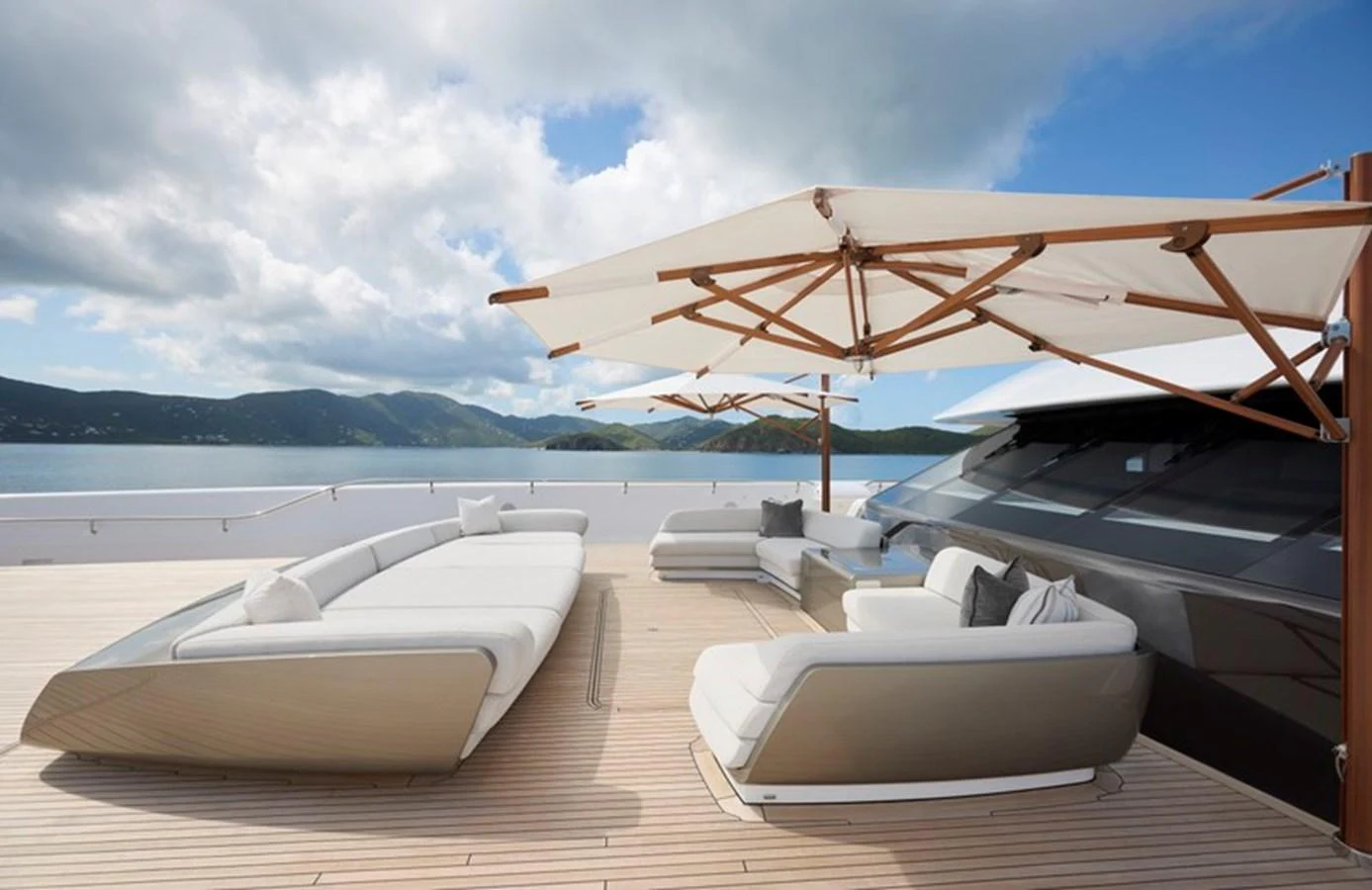 a group of lounge chairs on a beach with a large umbrella aboard VANISH Yacht for Sale