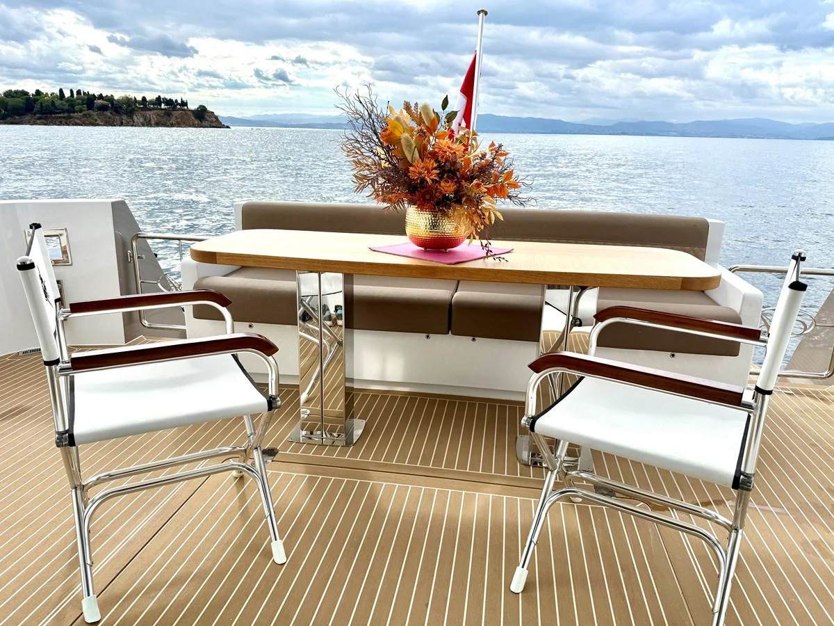 a table and chairs on a deck overlooking a body of water aboard SEA AT LAST Yacht for Sale