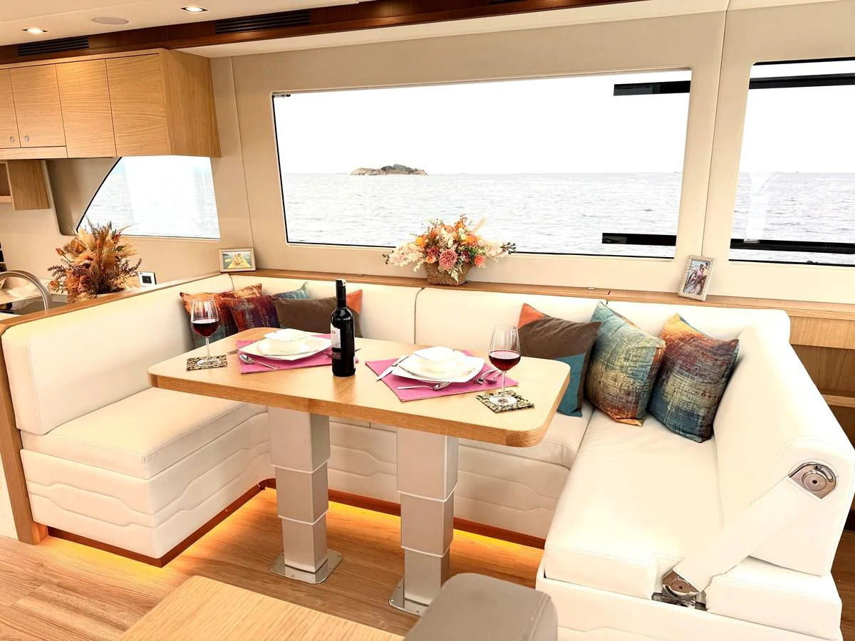 a living room with a table and chairs aboard SEA AT LAST Yacht for Sale