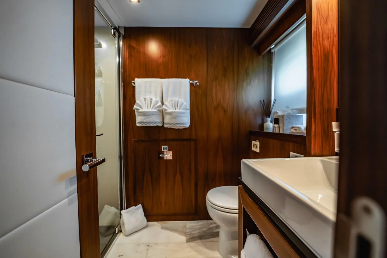 a bathroom with a wood door aboard PRECIOSO Yacht for Sale