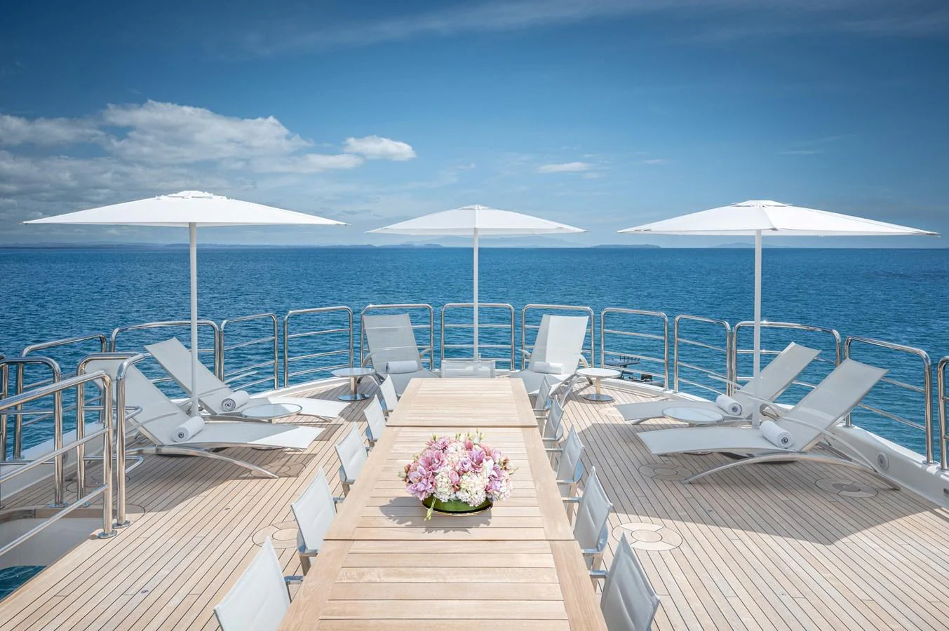 a deck with chairs and umbrellas aboard ODYSSEY Yacht for Sale