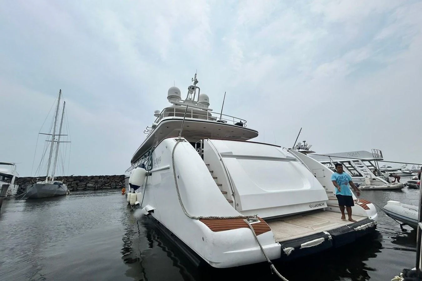 a person standing next to a boat aboard SUNSHINE Yacht for Sale