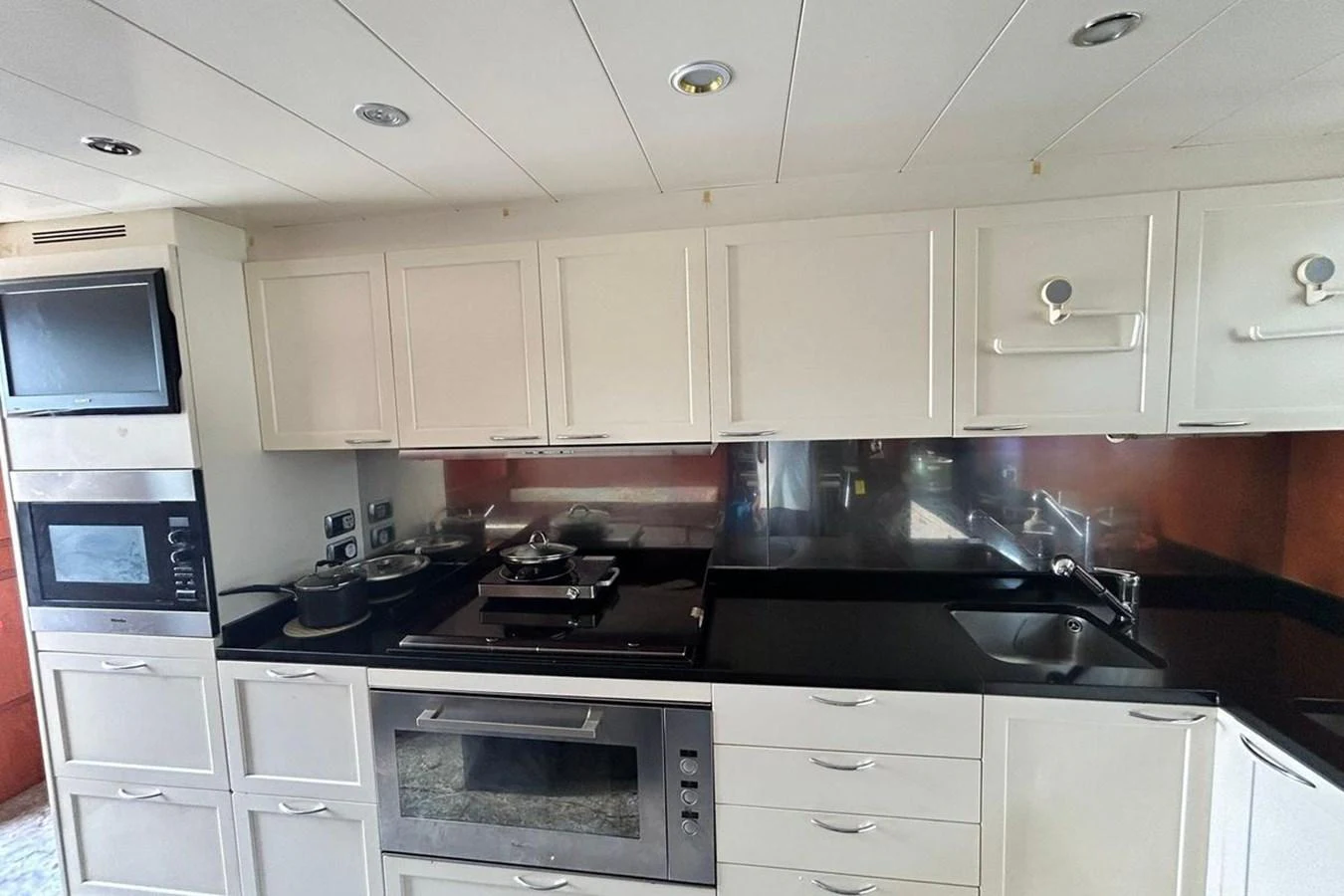 a kitchen with white cabinets aboard SUNSHINE Yacht for Sale