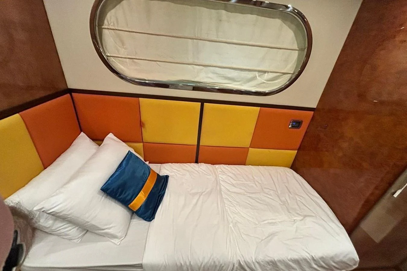 a bed with yellow and blue pillows aboard SUNSHINE Yacht for Sale