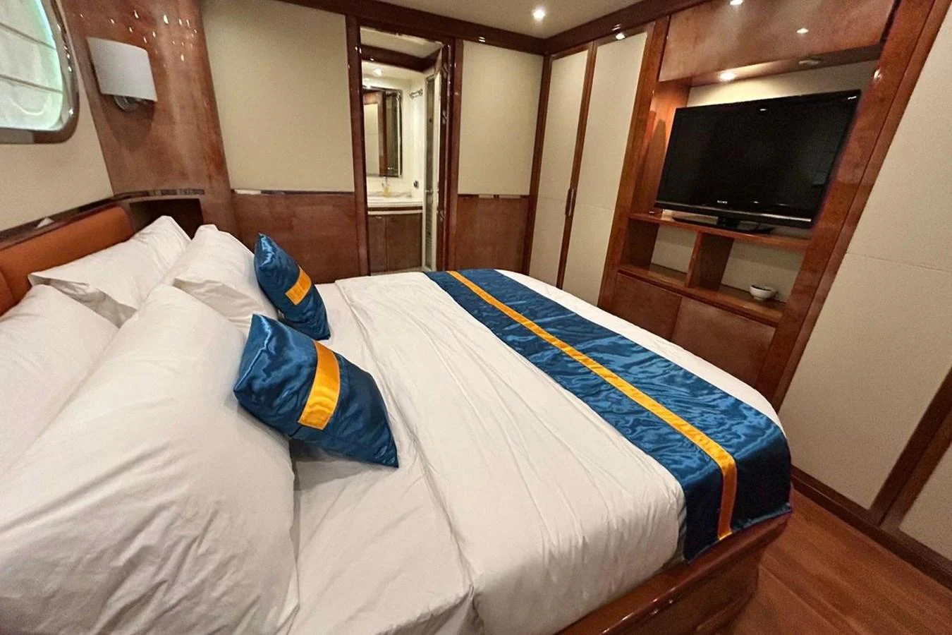 a bed with a blue and yellow blanket on it aboard SUNSHINE Yacht for Sale