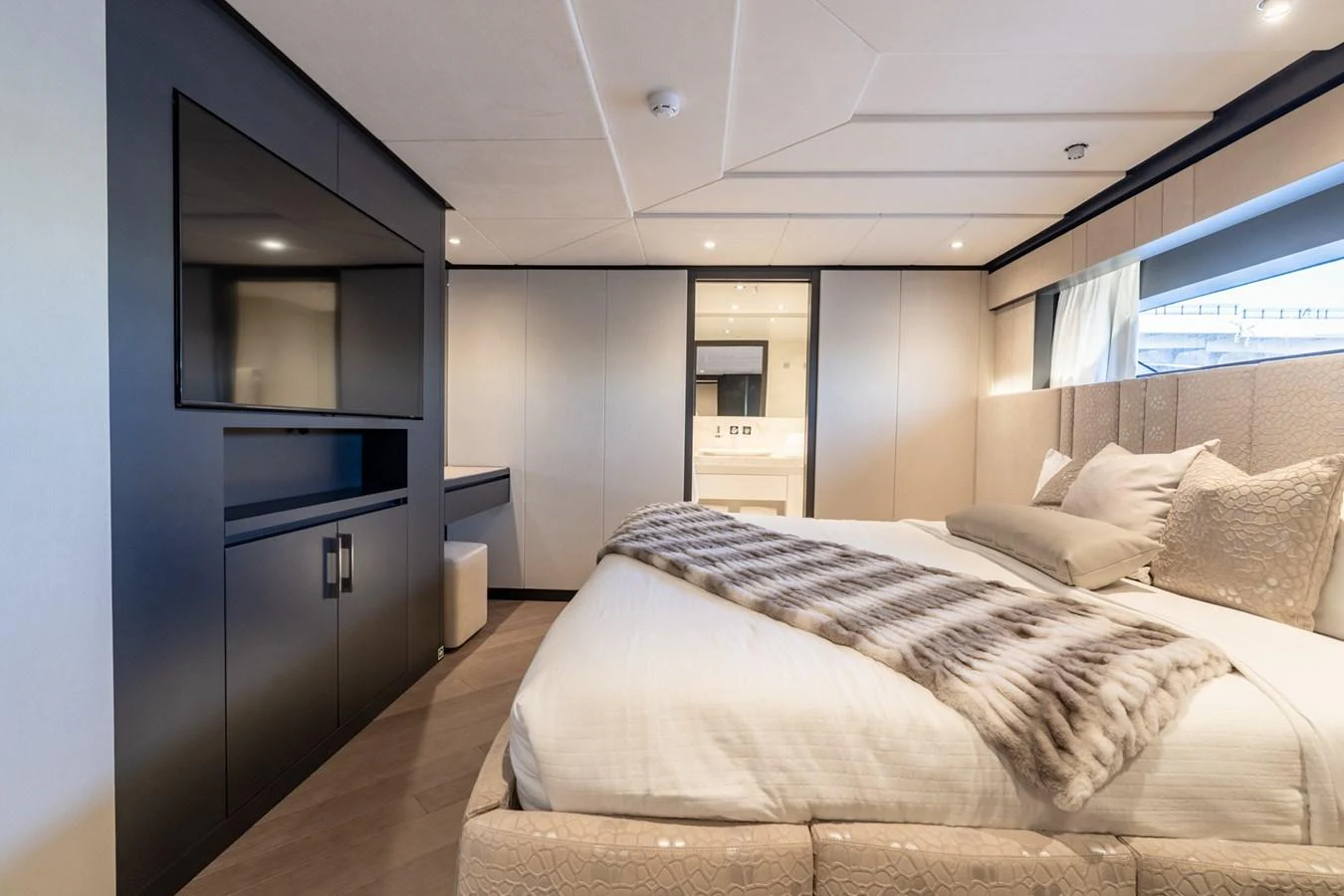 a bedroom with a bed and a tv aboard RESONANCE Yacht for Sale
