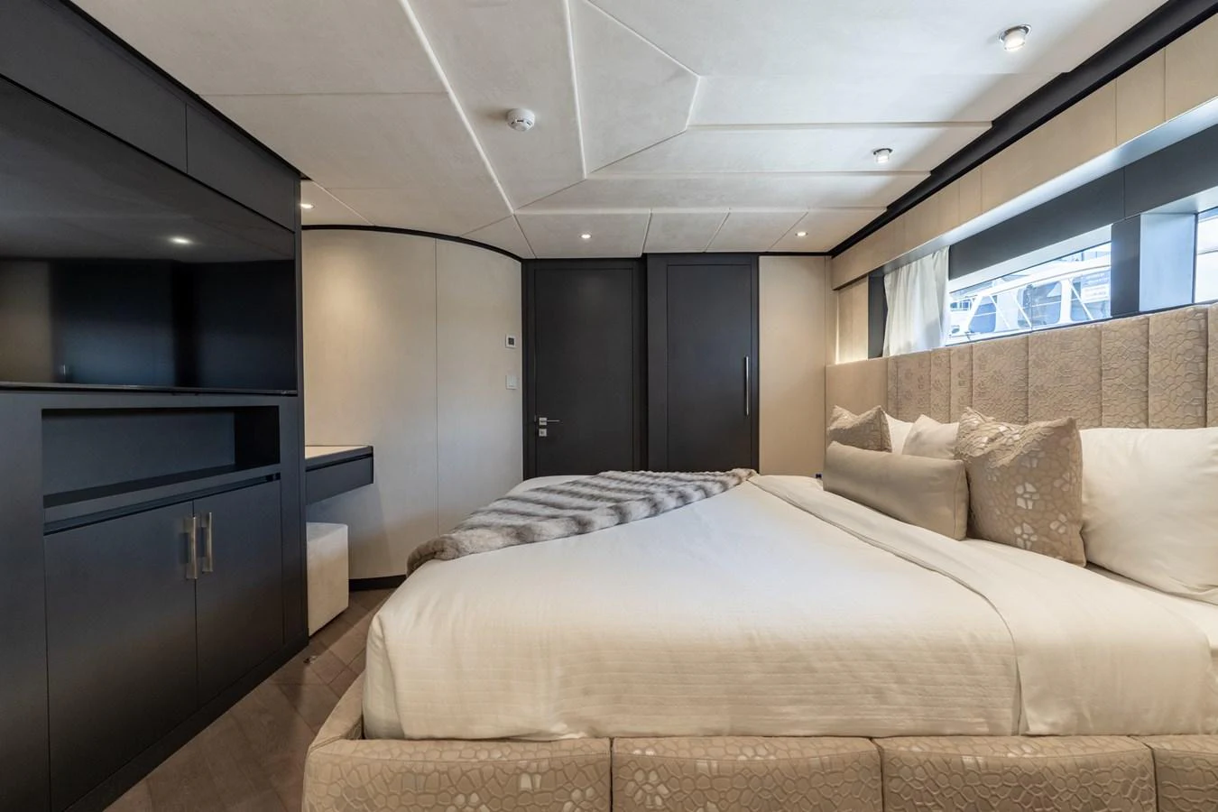 a bedroom with a bed and a window aboard RESONANCE Yacht for Sale