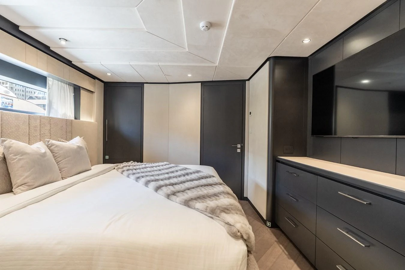 a bedroom with a bed and a dresser aboard RESONANCE Yacht for Sale
