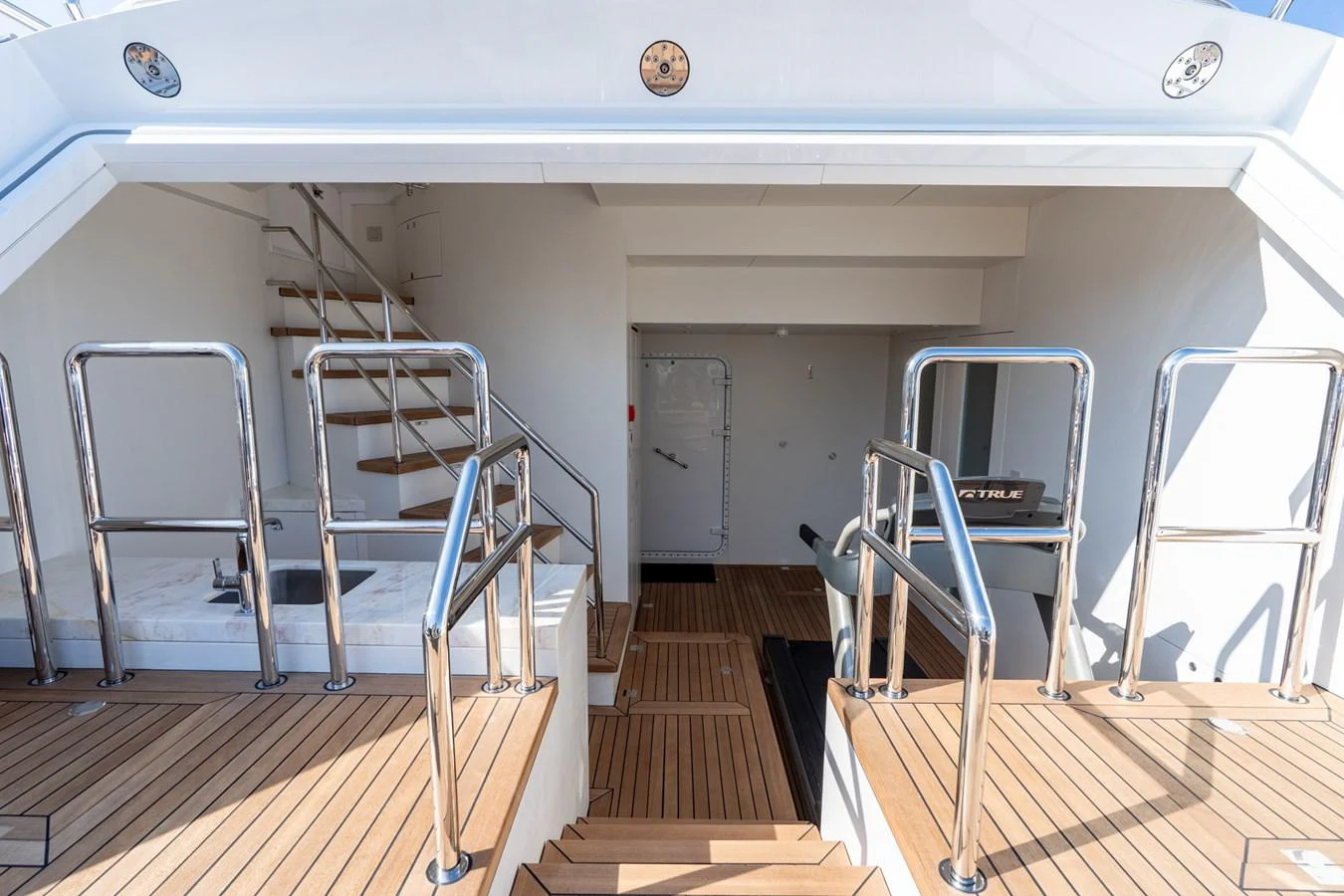 a set of white chairs on a wooden deck aboard RESONANCE Yacht for Sale