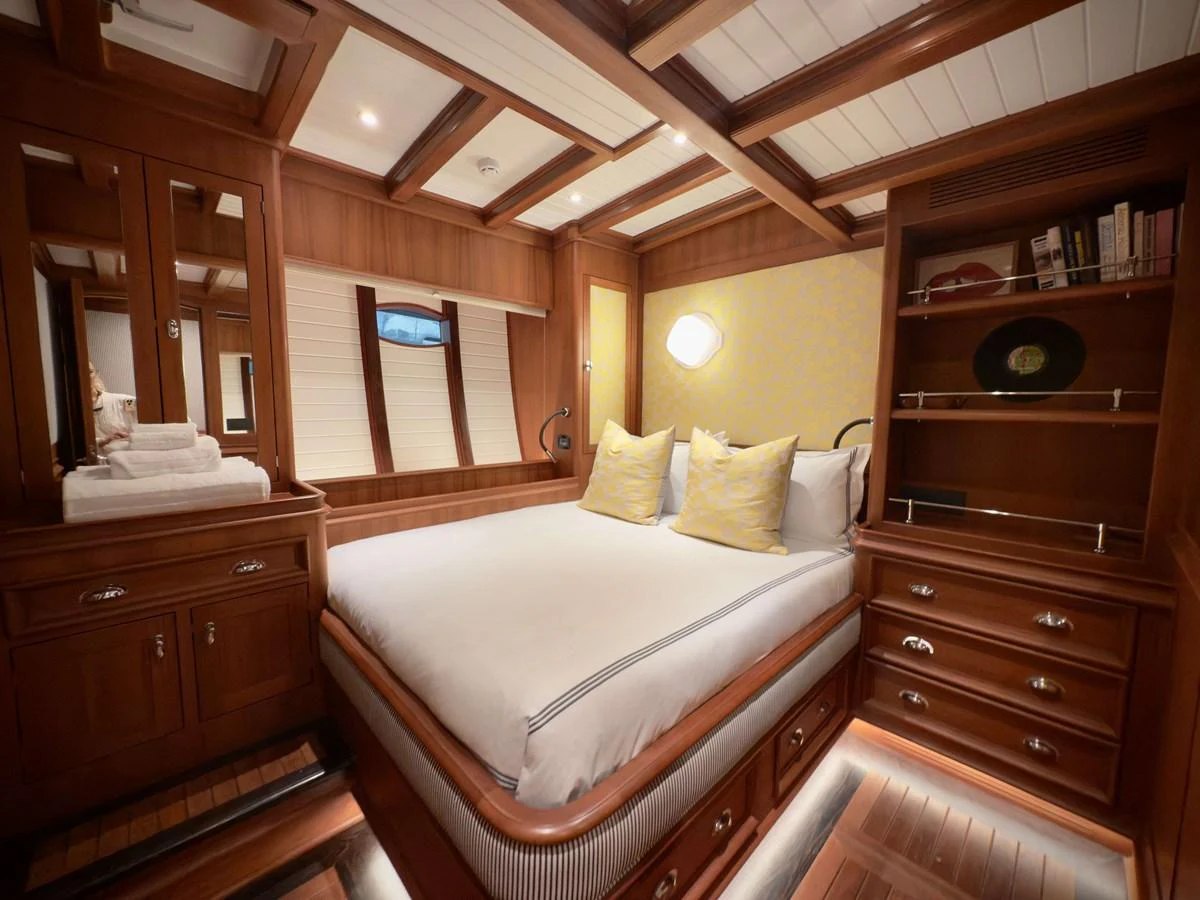 a bedroom with a bed and a mirror aboard NAMUUN Yacht for Sale