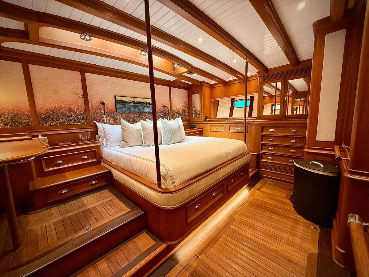 a room with a bed and a wood floor aboard NAMUUN Yacht for Sale