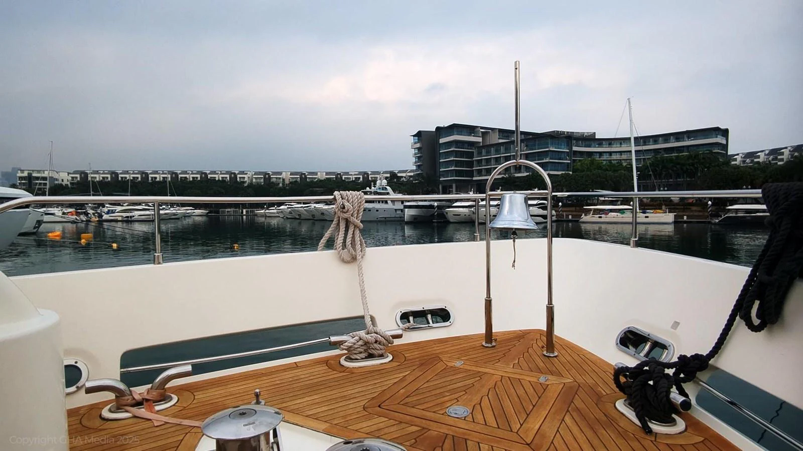 a table with glasses and a glass on it by a window with a city in the background aboard OXYGEN Yacht for Sale
