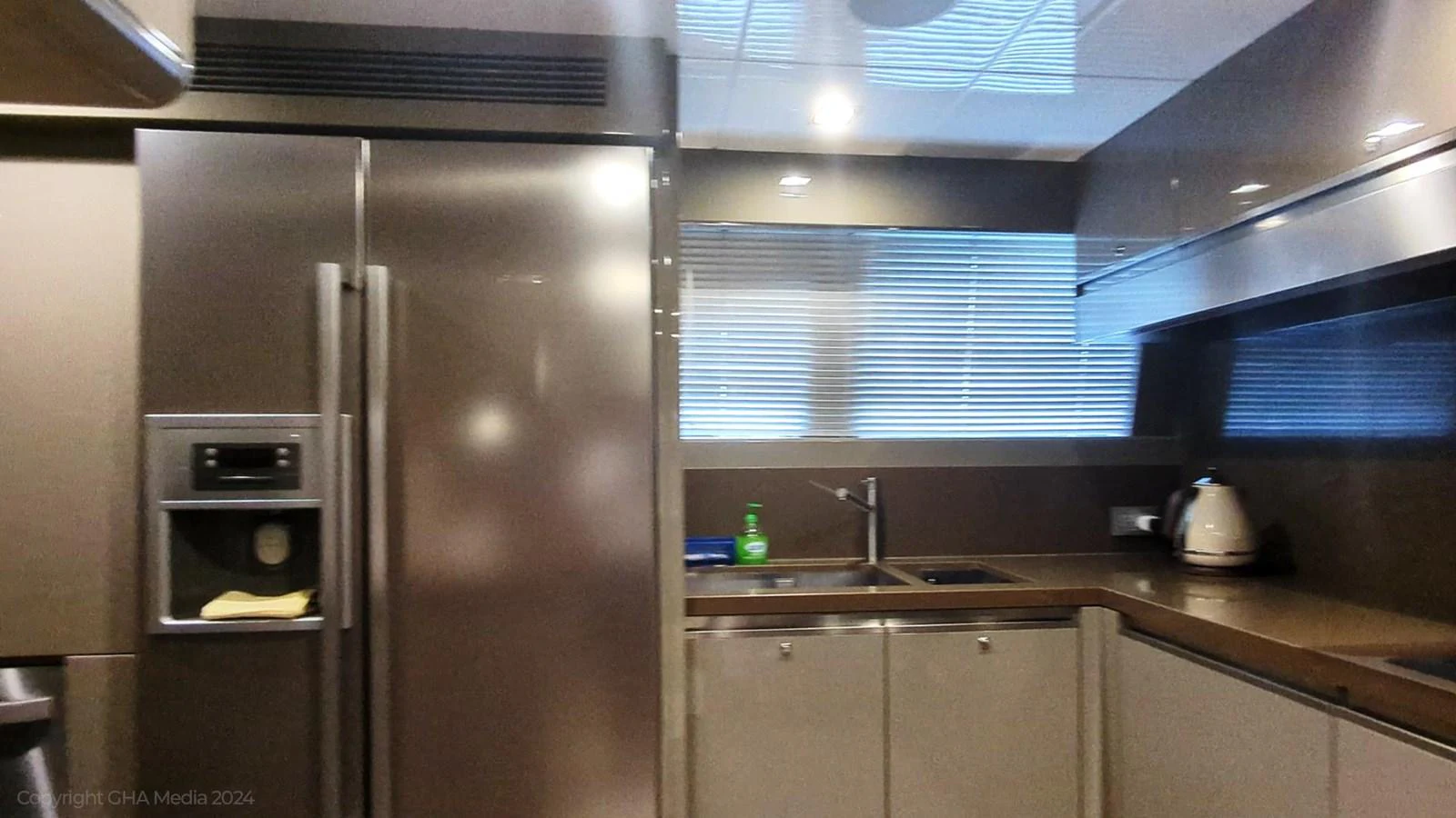 a kitchen with a stainless steel refrigerator aboard OXYGEN Yacht for Sale