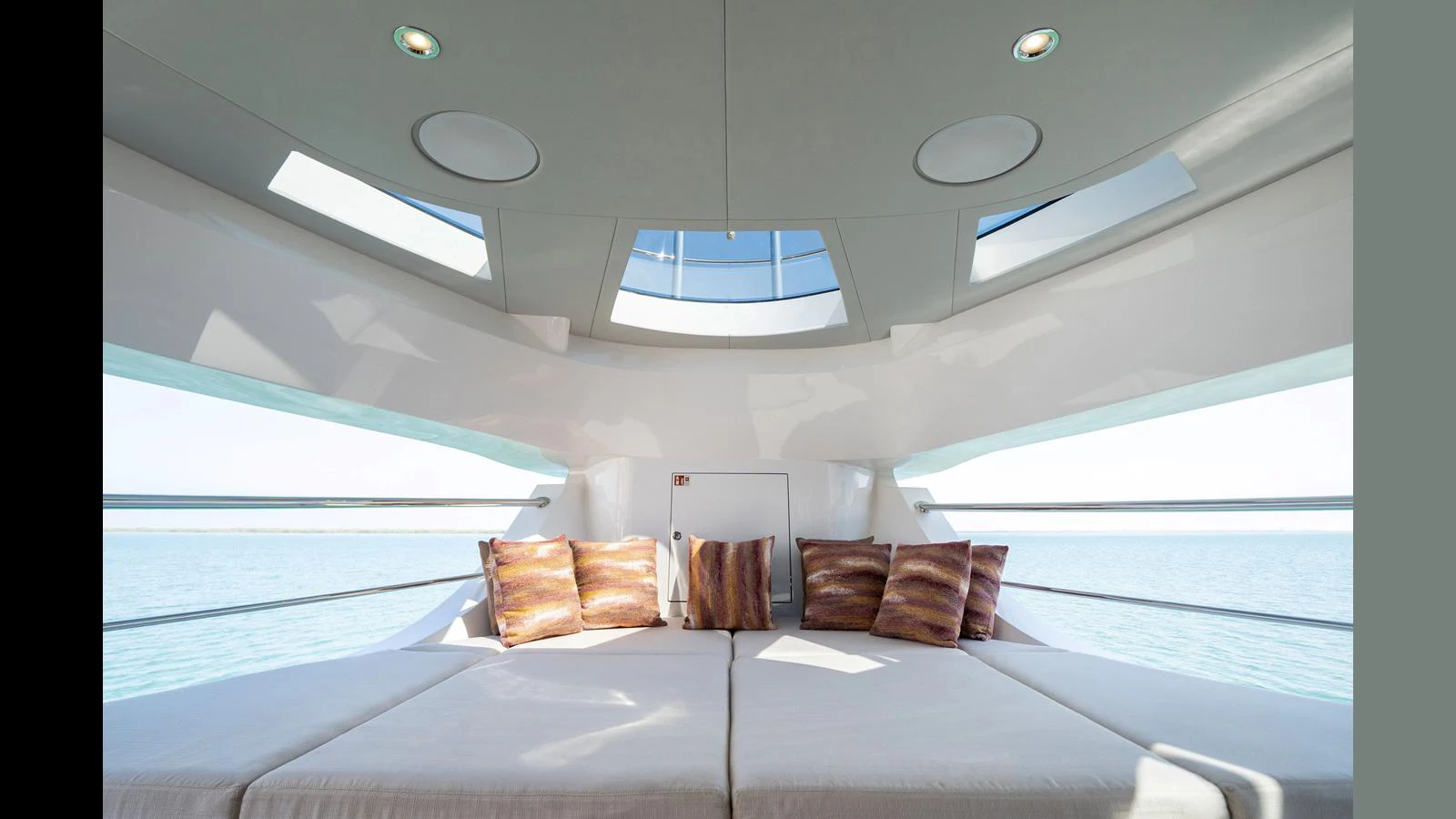 a bed with a white bed and a white table with a white chair aboard 100 TERRACE Yacht for Sale