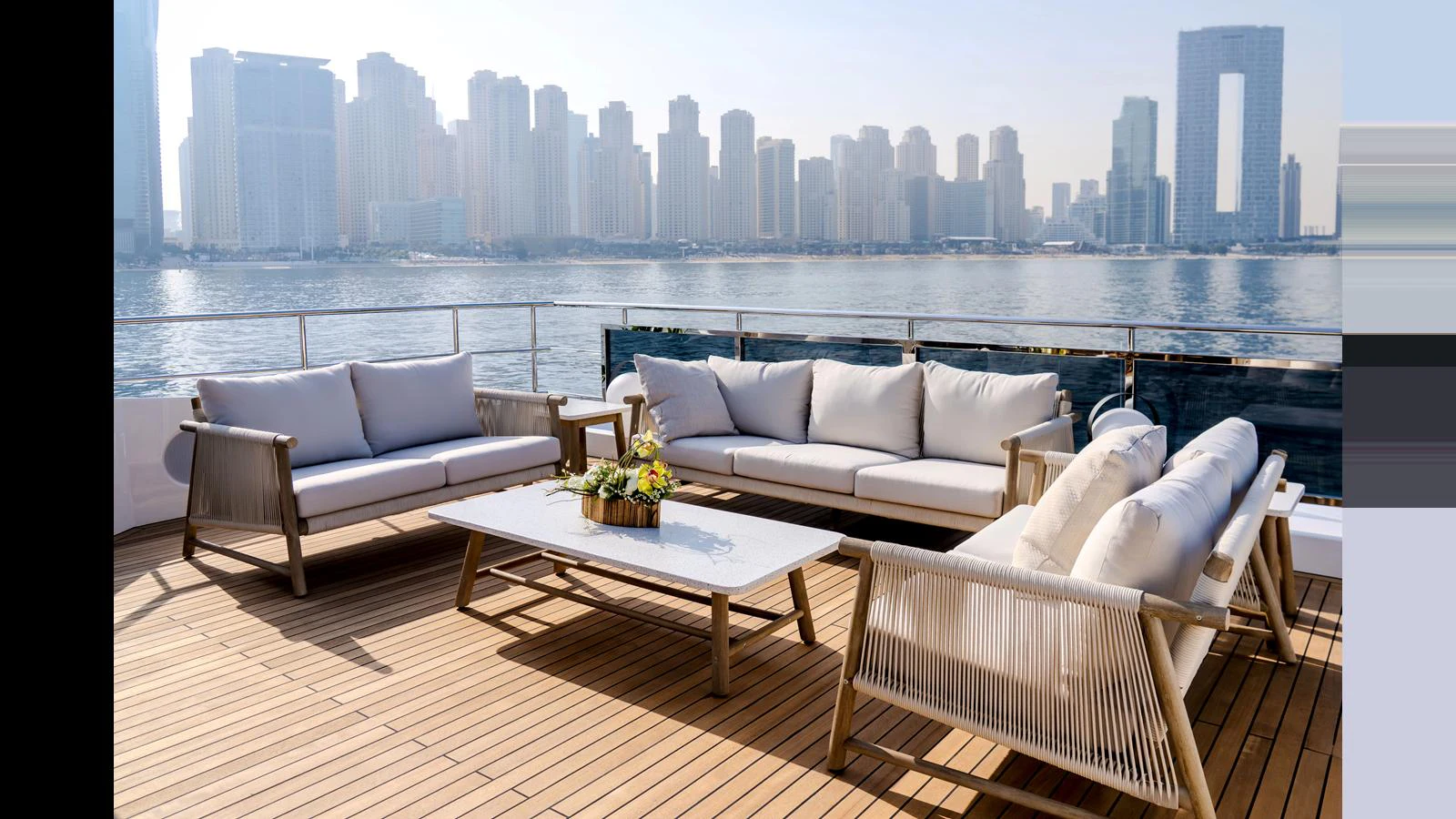 a room with couches and a table and a city in the background aboard 100 TERRACE Yacht for Sale
