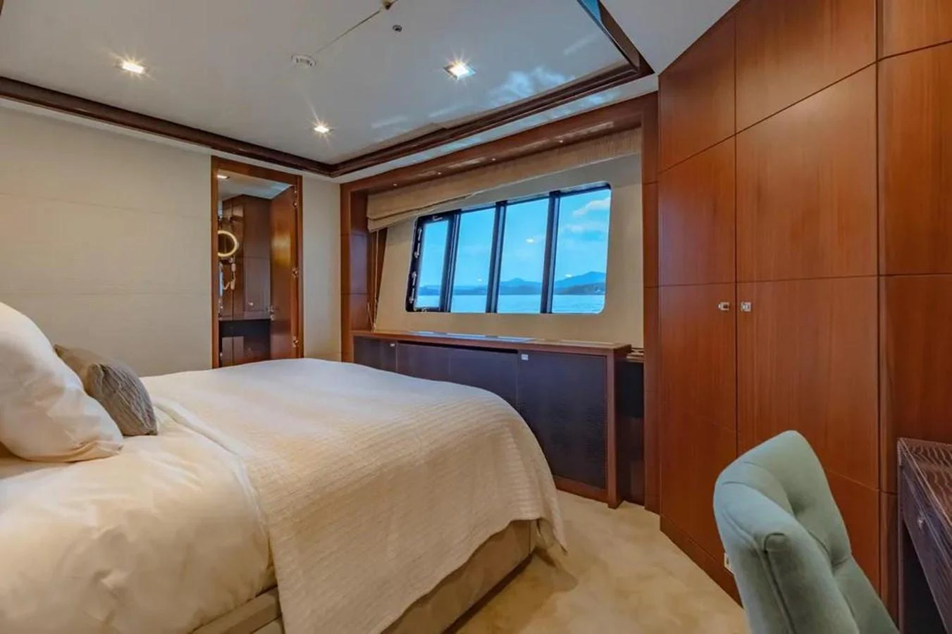 a bedroom with a bed and a chair aboard BLUE MOON Yacht for Sale
