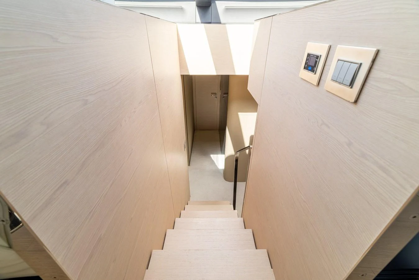 A sleek and modern staircase leads down to the lower deck of the yacht. aboard SABI Yacht for Sale