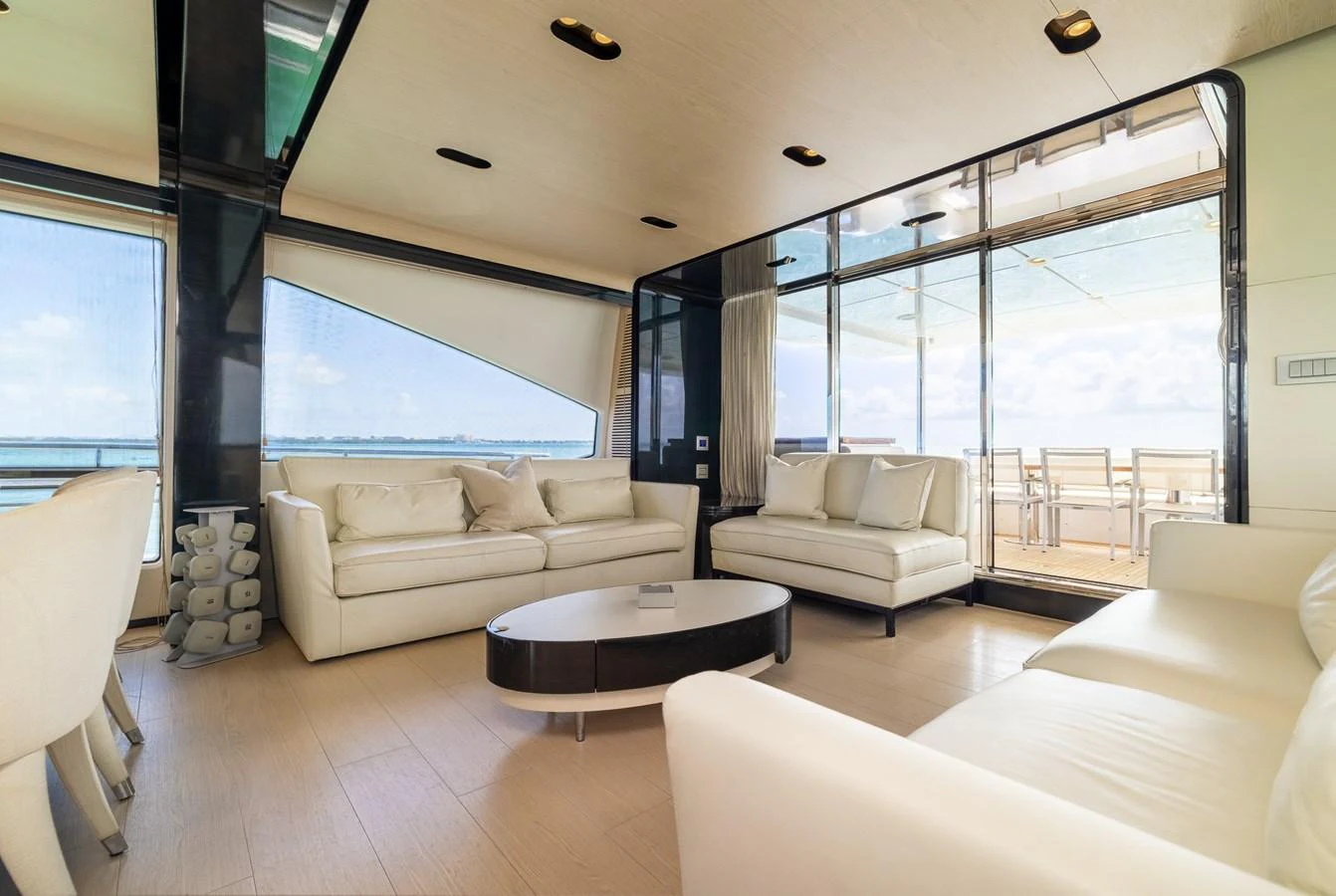 The salon features plush white seating with expansive windows offering stunning views. aboard SABI Yacht for Sale